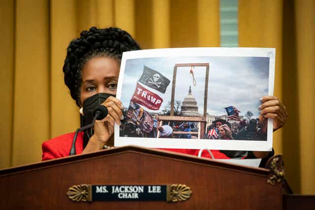 <p>Sheila Jackson Lee holds a photo of the crowd at the 6 January insurrection  during a House committee hearing on 24 February.</p>