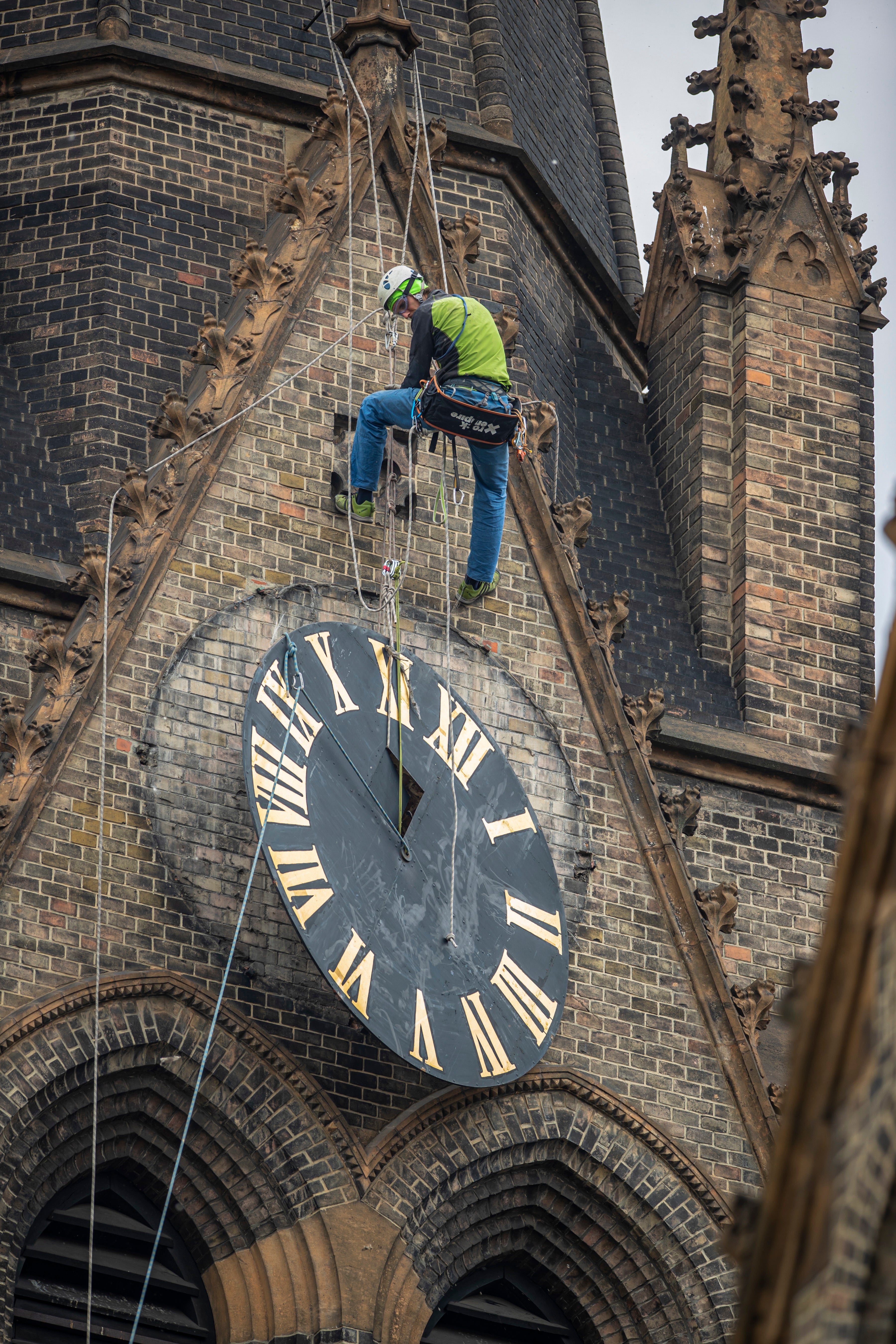 A mountaineer removes a dial from the tower during maintenance of the tower's clock at the Church of St Ludmila in Prague
