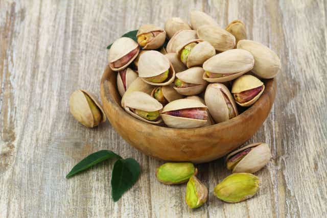 Pistachios in wooden bowl with copy space