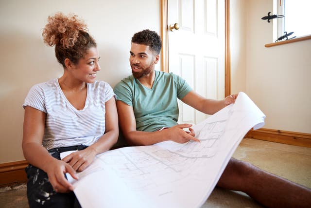 Couple looking at floor plans for a home renovation