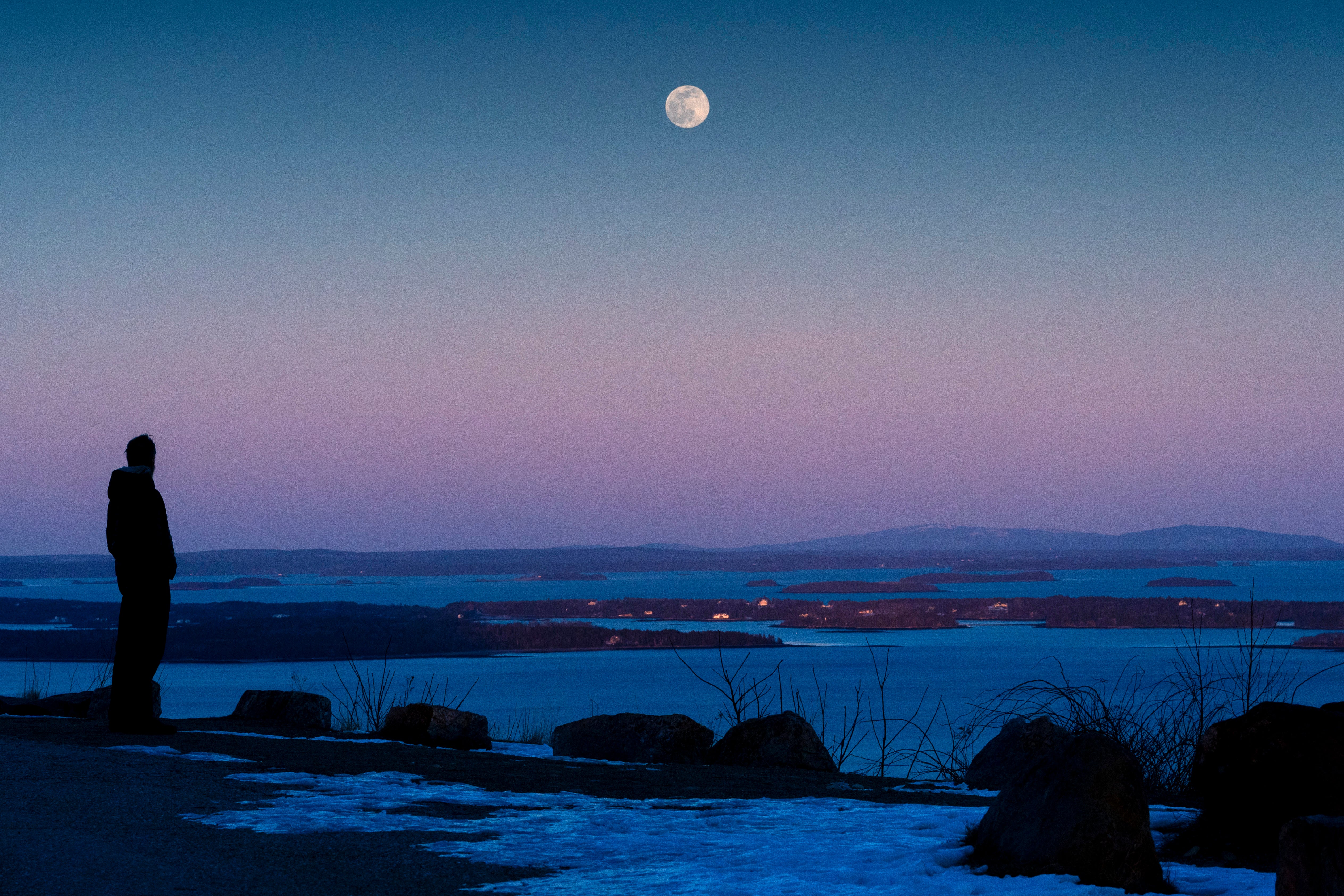 Shawn Griffith, of South Port, Maine, watches the “snow moon” rise in clear skies over Penobscot Bay