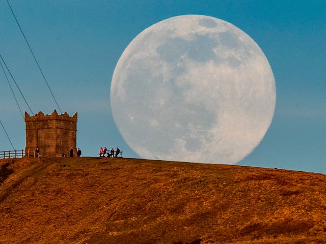 <p>The snow moon rises behind Rivington Pike near Bolton, Greater Manchester.</p>