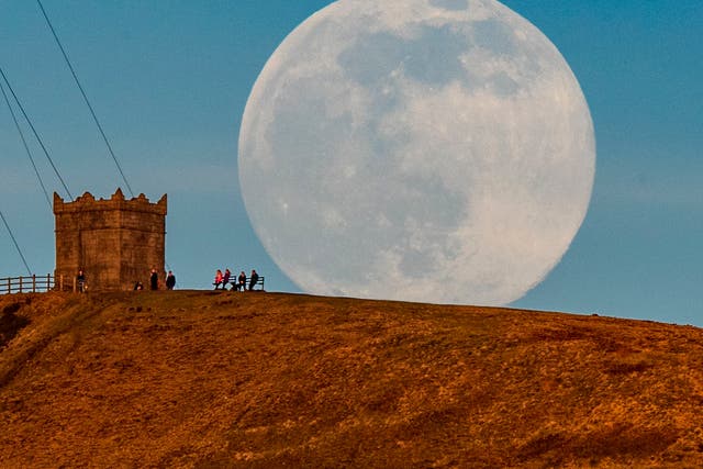 <p>The snow moon rises behind Rivington Pike near Bolton, Greater Manchester.</p>
