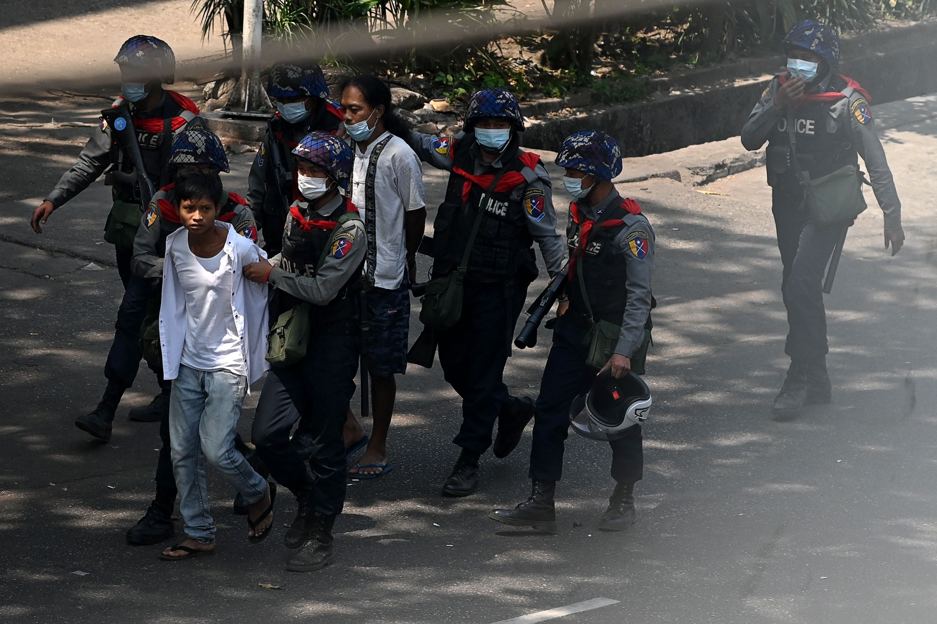 Police arrest people in Yangon on 27 February as protesters demonstrate against country’s military coup