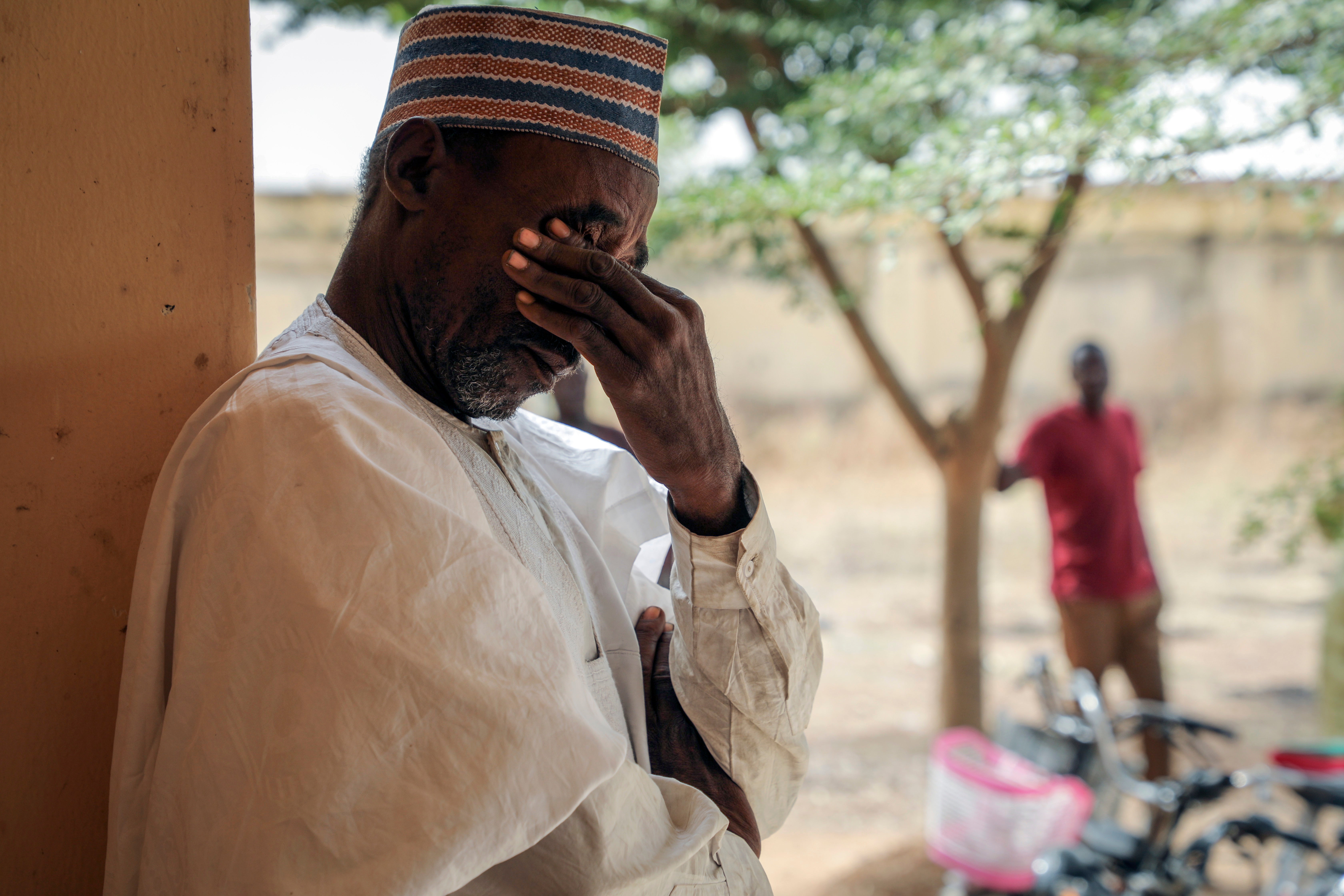 <p>Father Aliyu Ladan Jangebe, whose four daughters are among more than 300 girls who were abducted by gunmen on Friday from the Government Girls Junior Secondary School, waits for news</p>