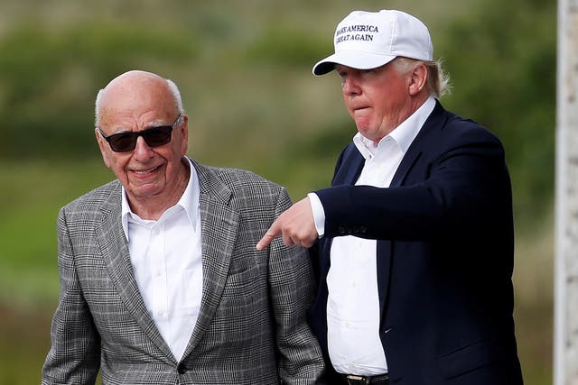 Donald Trump habla con el magnate de los medios Rupert Murdoch cuando salen de Trump International Golf Links en Aberdeen, Escocia, el 25 de junio de 2016.