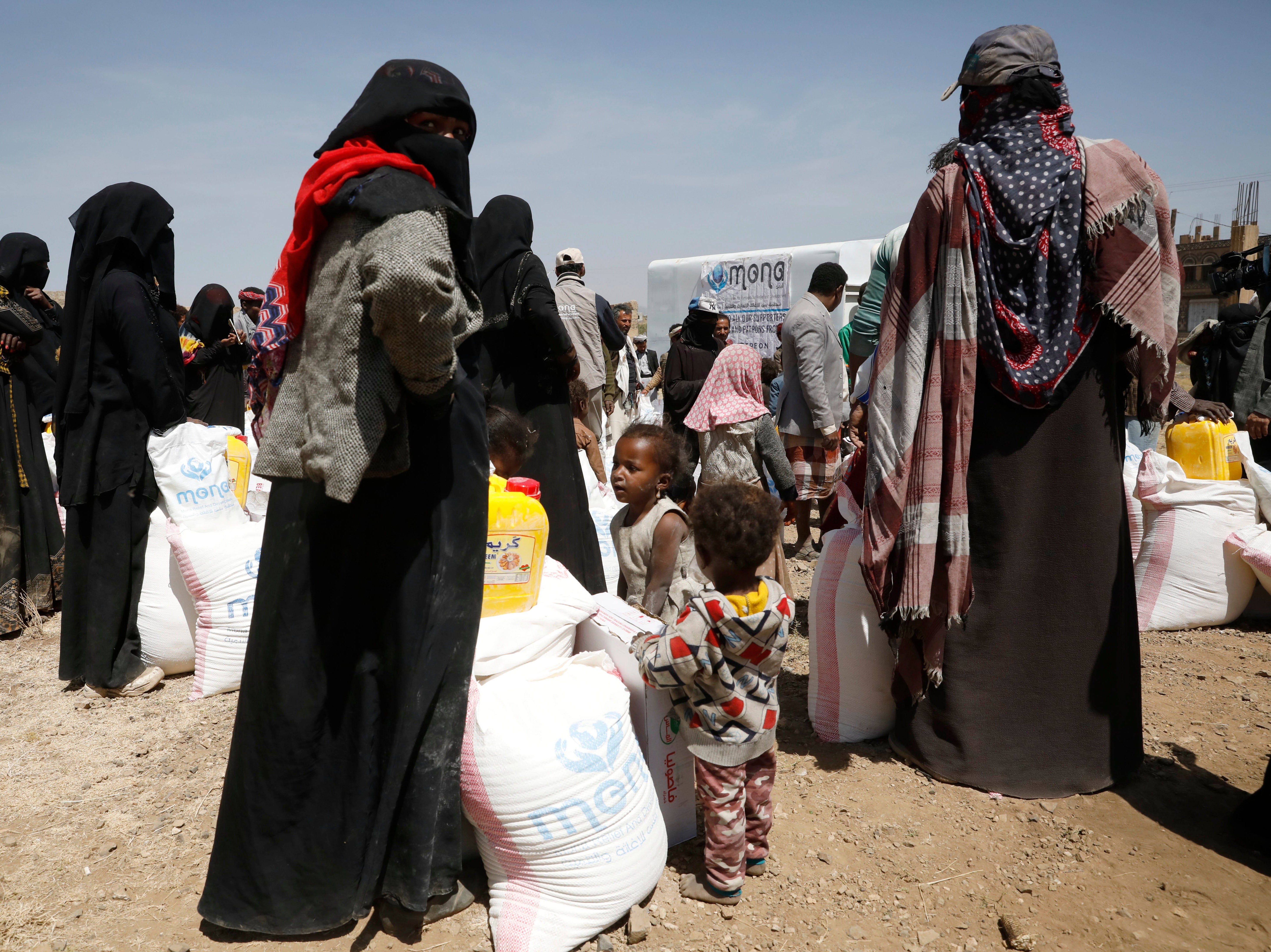Yemenis are given food rations by the Mona Relief charity at a displaced persons camp in Sanaa