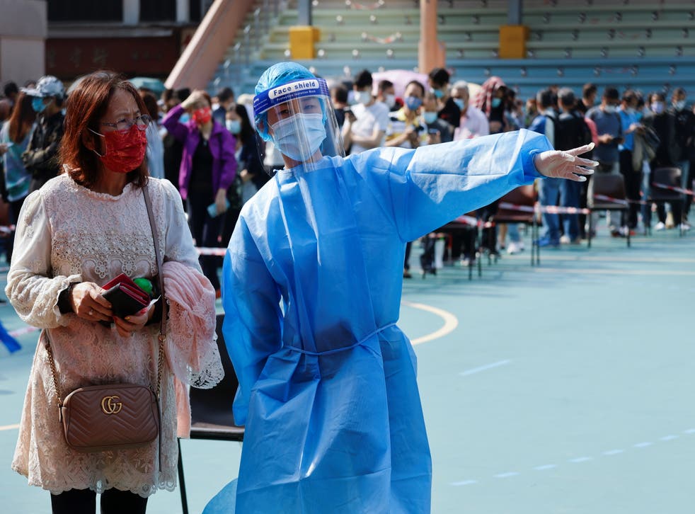 <p>A health worker guides a woman to queue up at a makeshift community testing centre for the coronavirus disease (COVID-19), in Hong Kong, China </p>