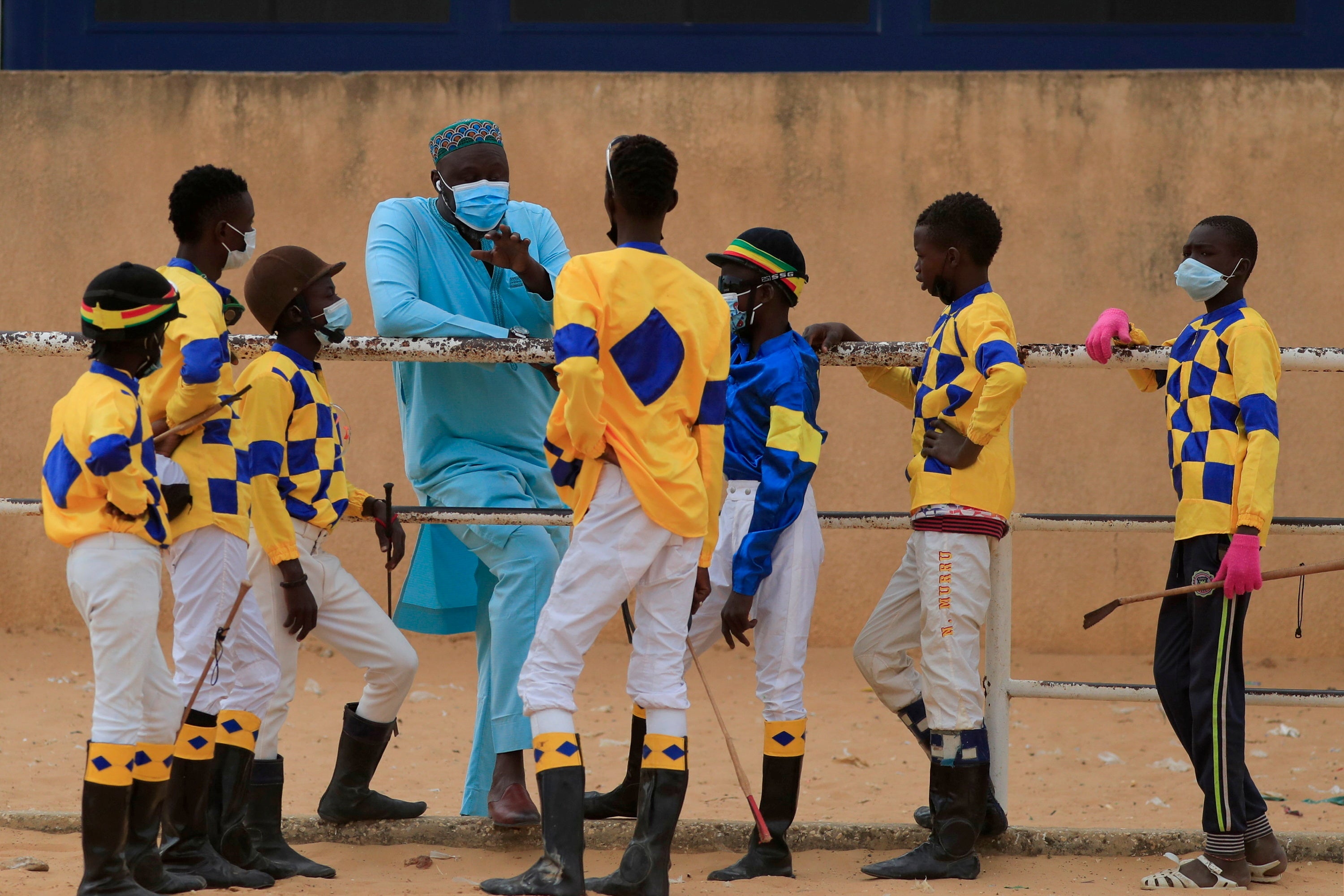 Adama Bao, a coach who owns the Lambafar stable, speaks to Diop and other jockeys before a race
