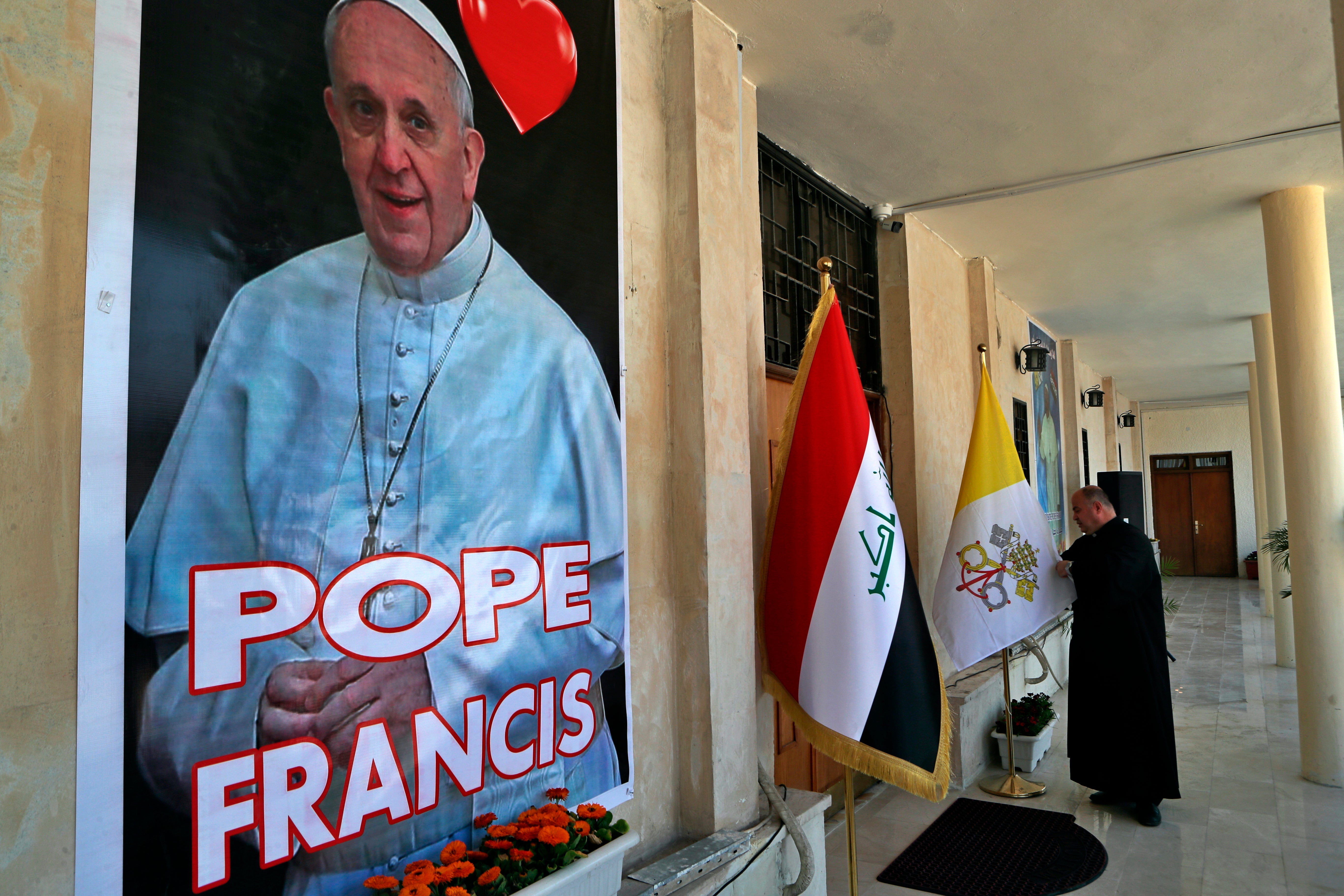 Father Nazeer Dako arranges a Vatican flag to welcome Pope Francis at St Joseph’s Chaldean Church in Baghdad
