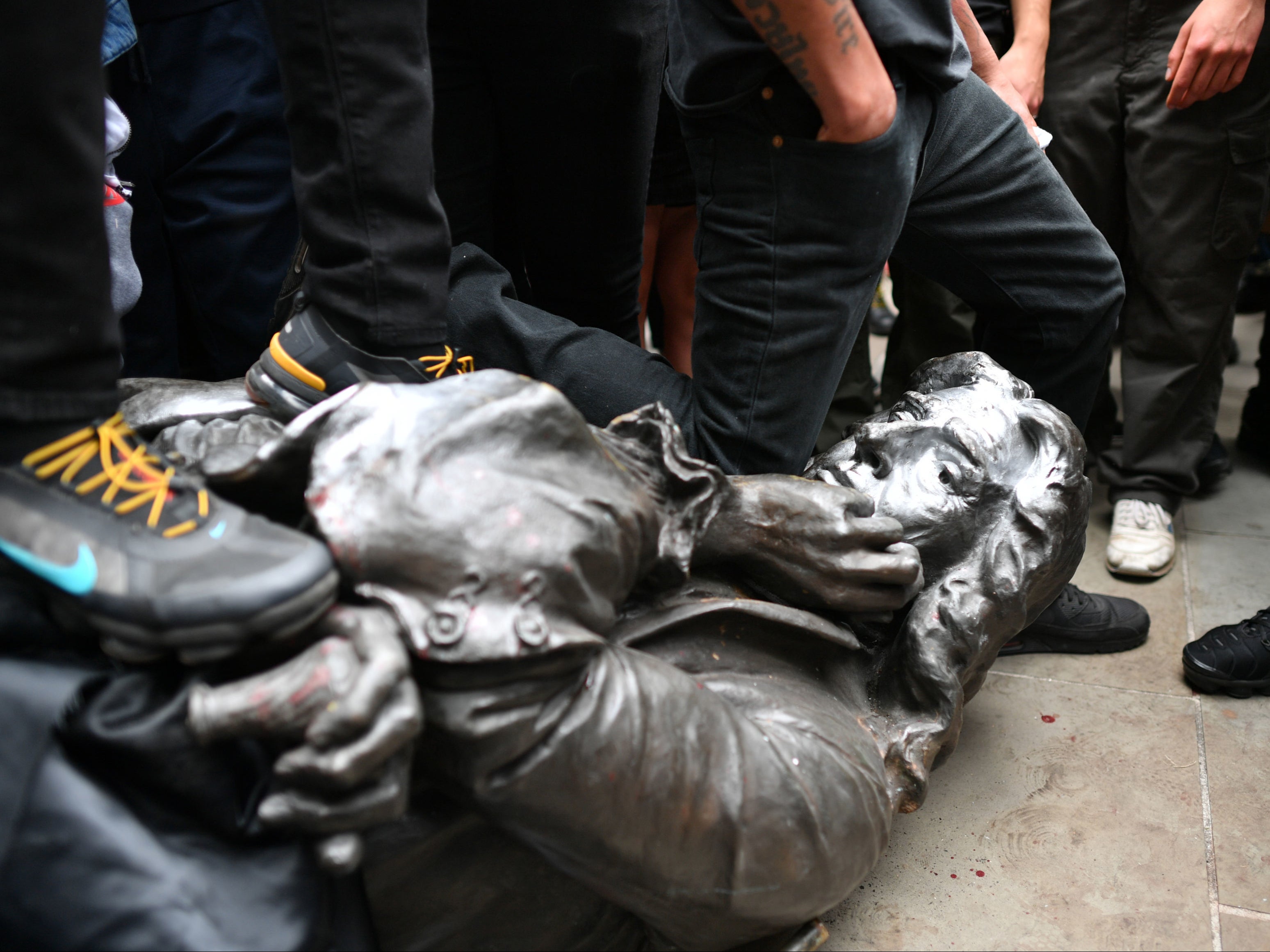 The Edward Colston statue at the feet of protesters after it was pulled down during a Black Lives Matter rally
