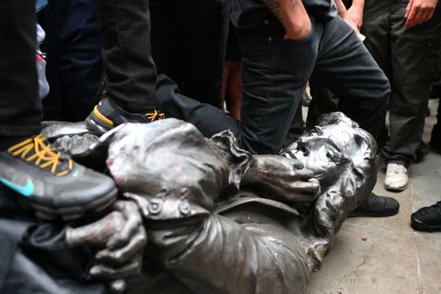 The Edward Colston statue at the feet of protesters after it was pulled down during a Black Lives Matter rally