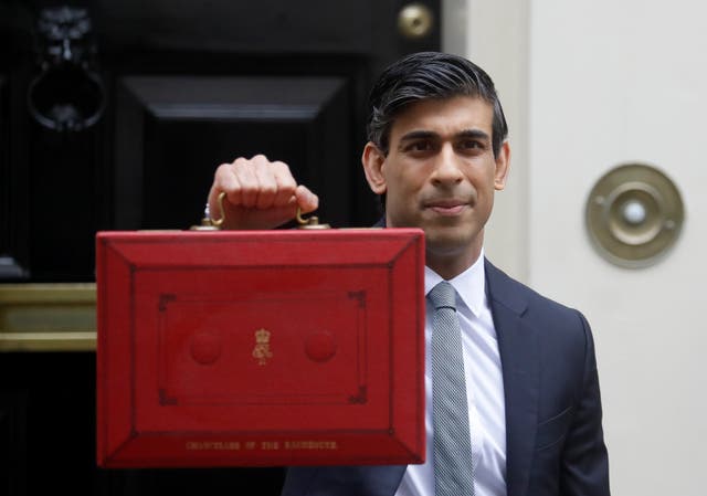 Rishi Sunak stands with his red briefcase in front of 11 Downing Street