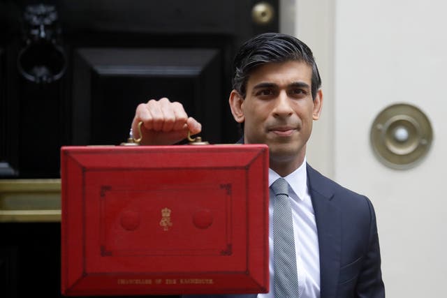Rishi Sunak stands with his red briefcase in front of 11 Downing Street