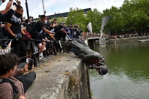 Protesters throw the statue of Edward Colston into Bristol harbour during a Black Lives Matter protest rally last June