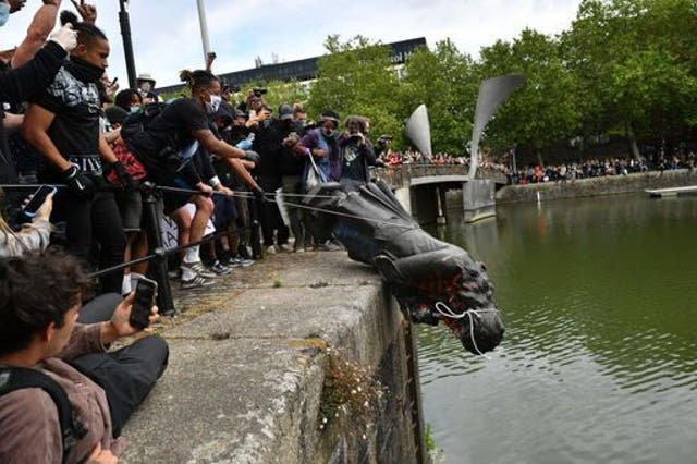 <p>Protesters throw the statue of Edward Colston into Bristol harbour in June</p>