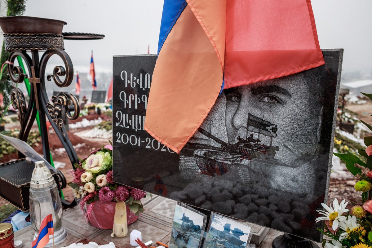 The face of a soldier who died aged 20 during the Karabakh war is engraved in a tombstone at the cemetery