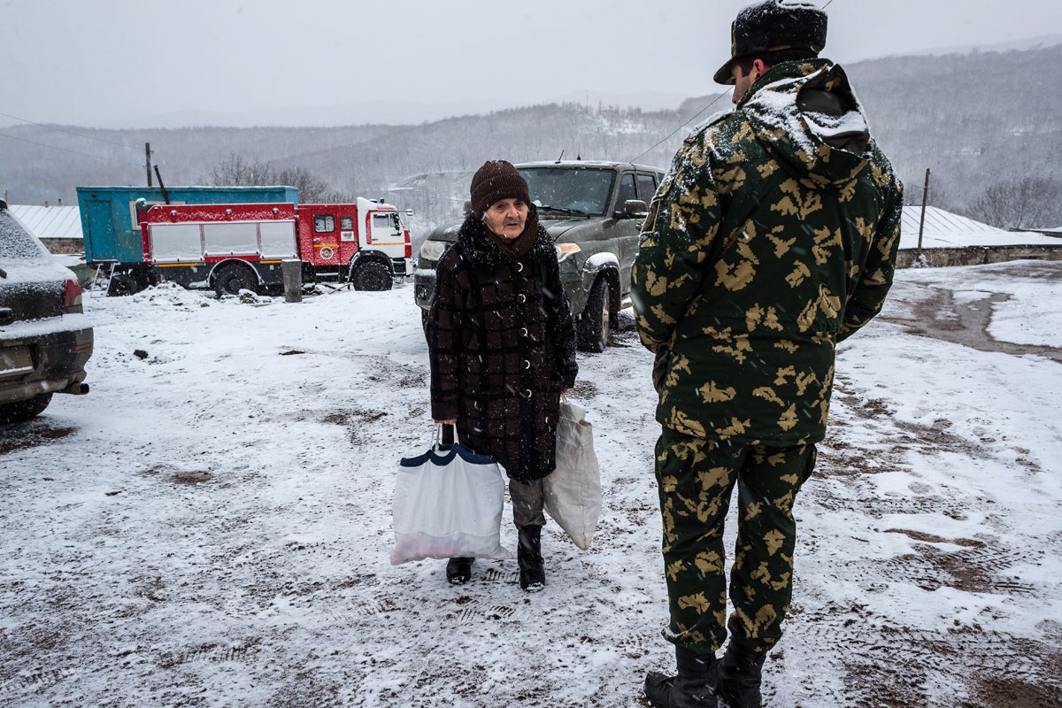 An elderly woman asks a soldier to escort her to her house in Shurnukh, Syunik province, Armenia. A road splits Shurnukh in two parts, one on the Armenian side and another one in Nagorno-Karabakh. With the Azerbaijani control of Nagorno-Karabakh the villagers need a permit from the Russian peacekeepers and escort of local militaries to move across the village