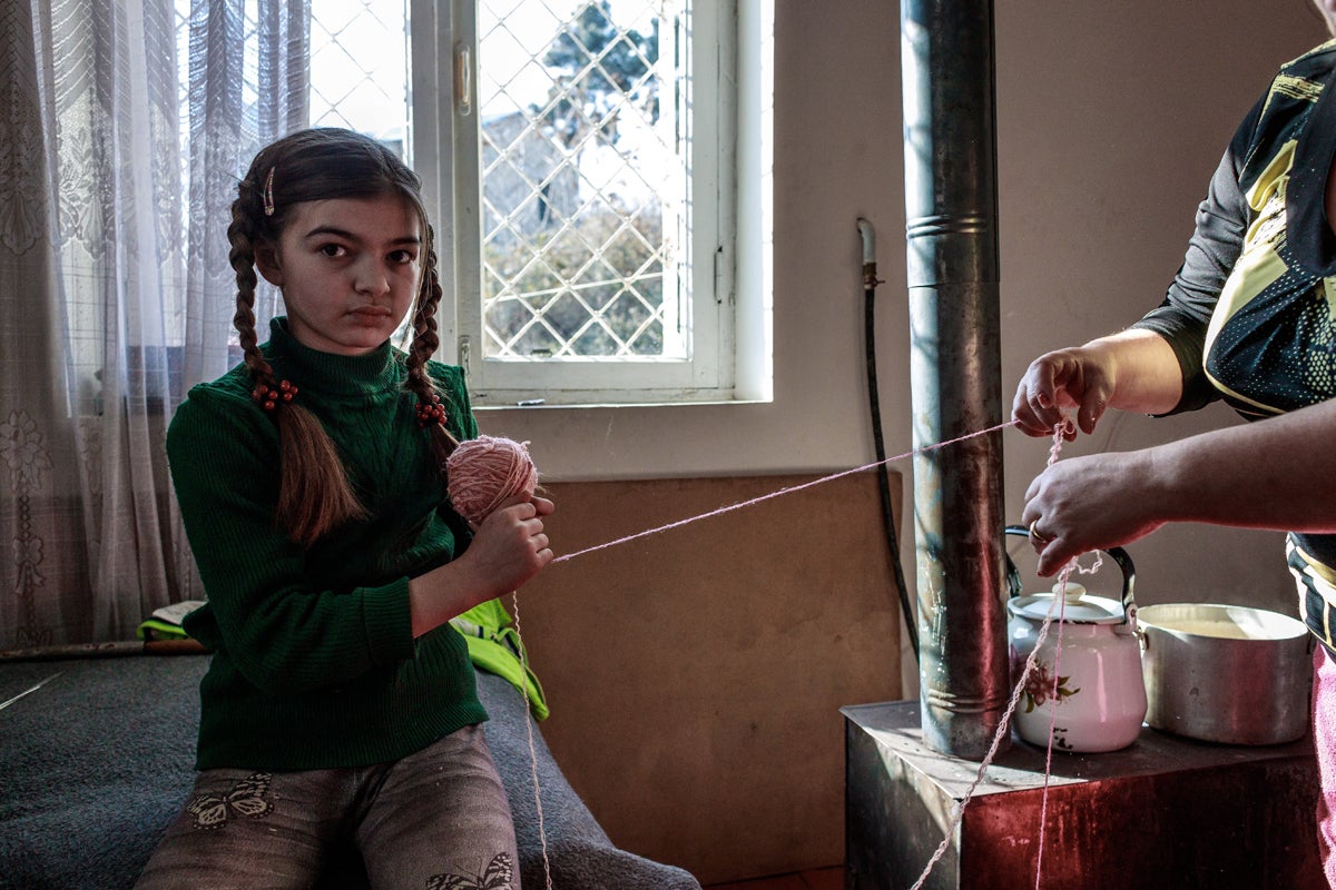 A girl and her mother spin a ball of wool in a house in Martuni. Both are refugees from Hadrut, Khojavend District of Azerbaijan and like many other families found a shelter in the city