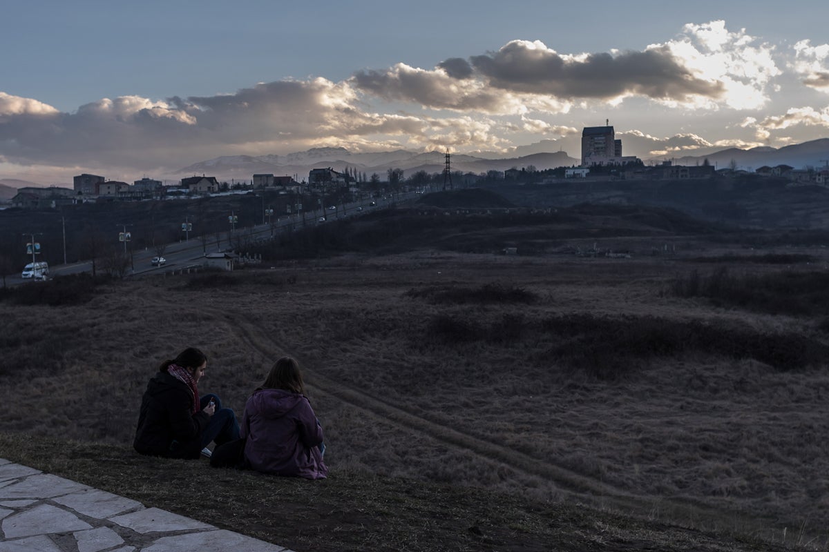 Teenagers sit near the We are our Mountains monument ( Dadik u Papik in Armenian) in Stepanakert, capital of Nagorno-Karabakh Republic. The agreement negotiated by Russia has yet to show how the normalisation of relations between Nagorno-Karabakh, Armenia and Azerbaijan would be possible and most people are frightened of a resumption of the conflict