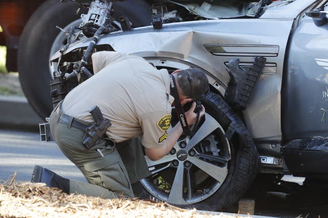 <p>A sheriff’s deputy examines the SUV crashed by Tiger Woods last week</p>