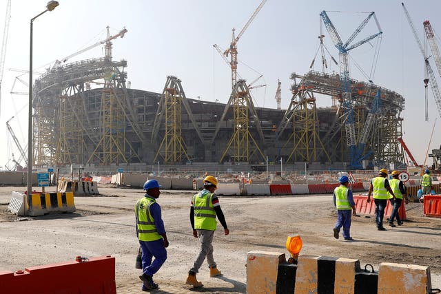 Workers walk towards the construction site of the Lusail Stadium, which will host the World Cup final in 2022