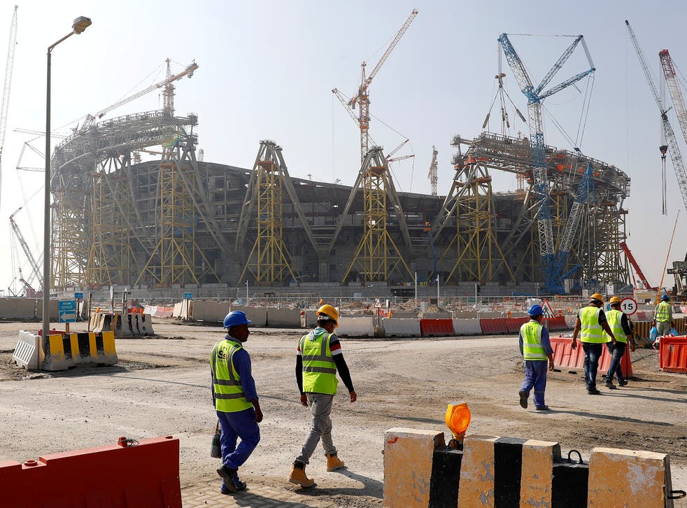 Workers walk towards the construction site of the Lusail Stadium, which will host the World Cup final in 2022