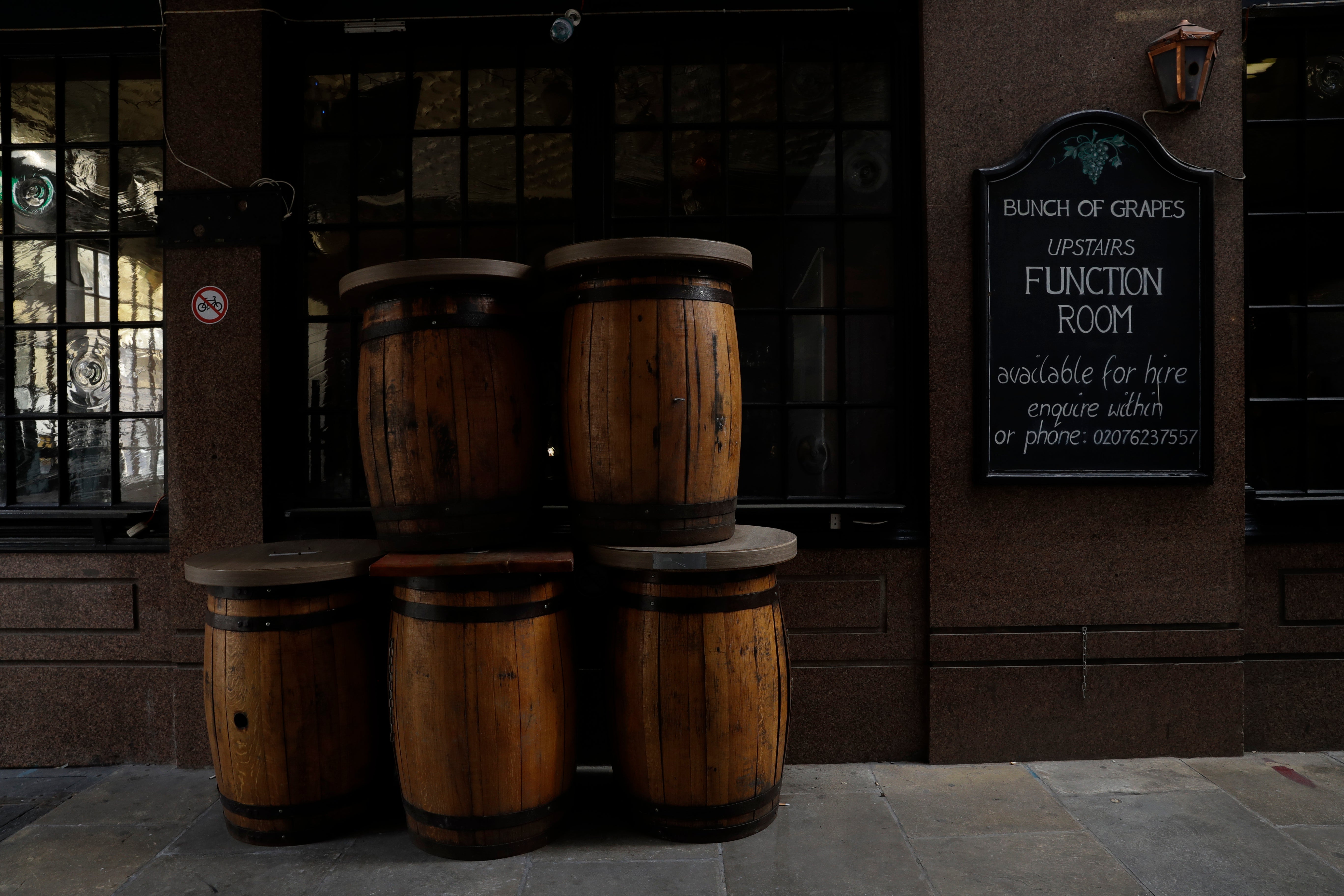 <p>File image: Barrel tables stand stacked up outside a temporarily closed pub in London</p>