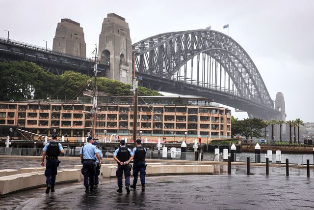 <p>FILE-New South Wales police officers patrol an area in front of the Harbour Bridge  in central Sydney on 31 December, 2020.</p>