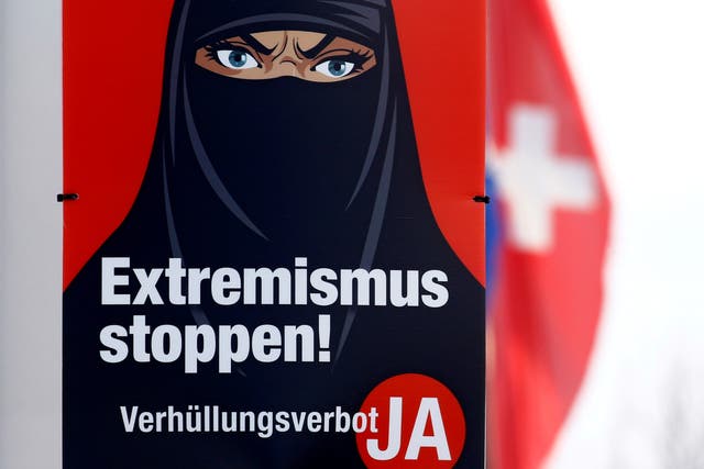A poster featuring a frowning woman wearing a black face covering and the words: ‘Stop extremism! Veil ban - Yes'
