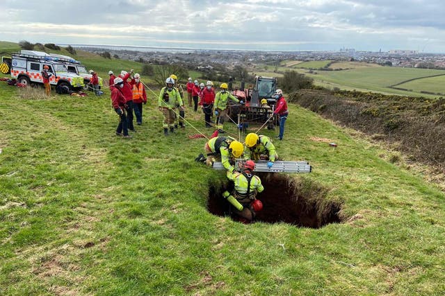 Rescuers from the Cumbria Fire and Rescue Service, and other agencies, work to pull the farmer up after he fell into a 60ft sinkhole with his quad bike