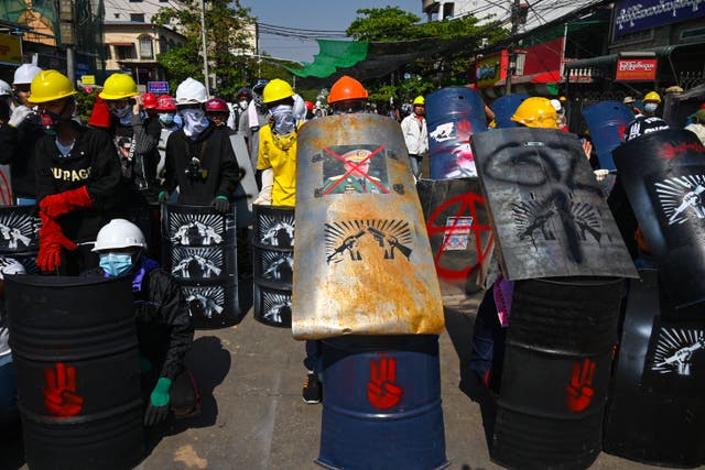 <p>A protester holds a makeshift shield with the picture of armed forces chief Senior General Min Aung Hlaing during a demonstration against the military coup in Yangon on 5 March 2021</p>