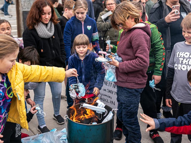 <p>Jóvenes asistentes arrojan cubrebocas quirúrgicas al fuego durante un evento de quema de máscaras en el Estado de Idaho el 6 de marzo de 2021 en Boise, Idaho. Los ciudadanos y políticos, incluida la vicegobernadora Janice McGeachin, se reunieron en al menos 20 ciudades de todo el estado para protestar contra las restricciones del COVID-19. </p>