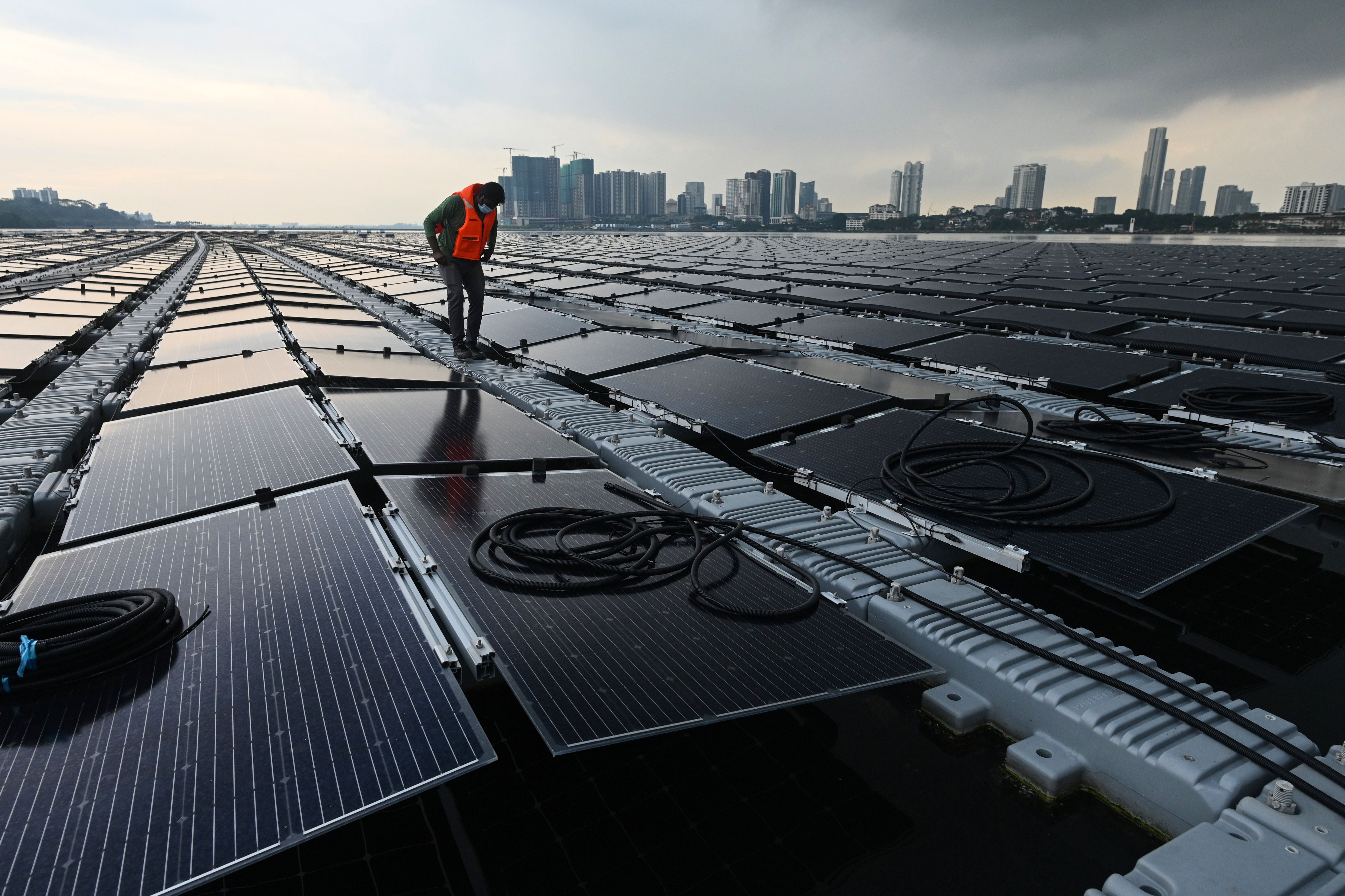 A worker checks cables on a floating solar power farm at sea off Singapore’s northern coast on 22 January, 2021.