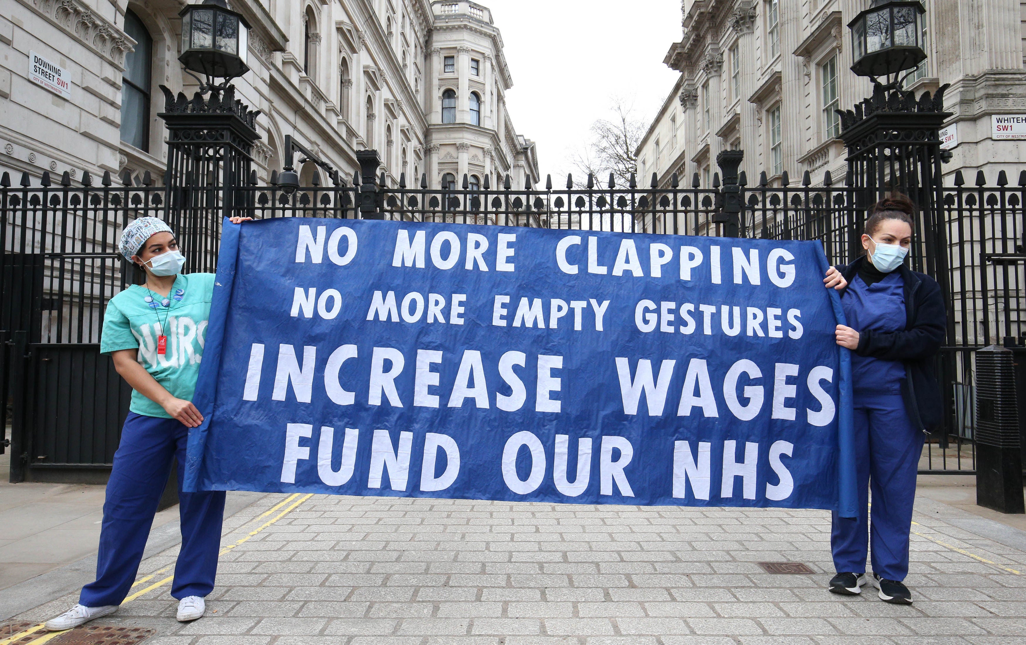 <p>Nurses and NHS workers hold a socially distanced protest outside Downing Street in London</p>