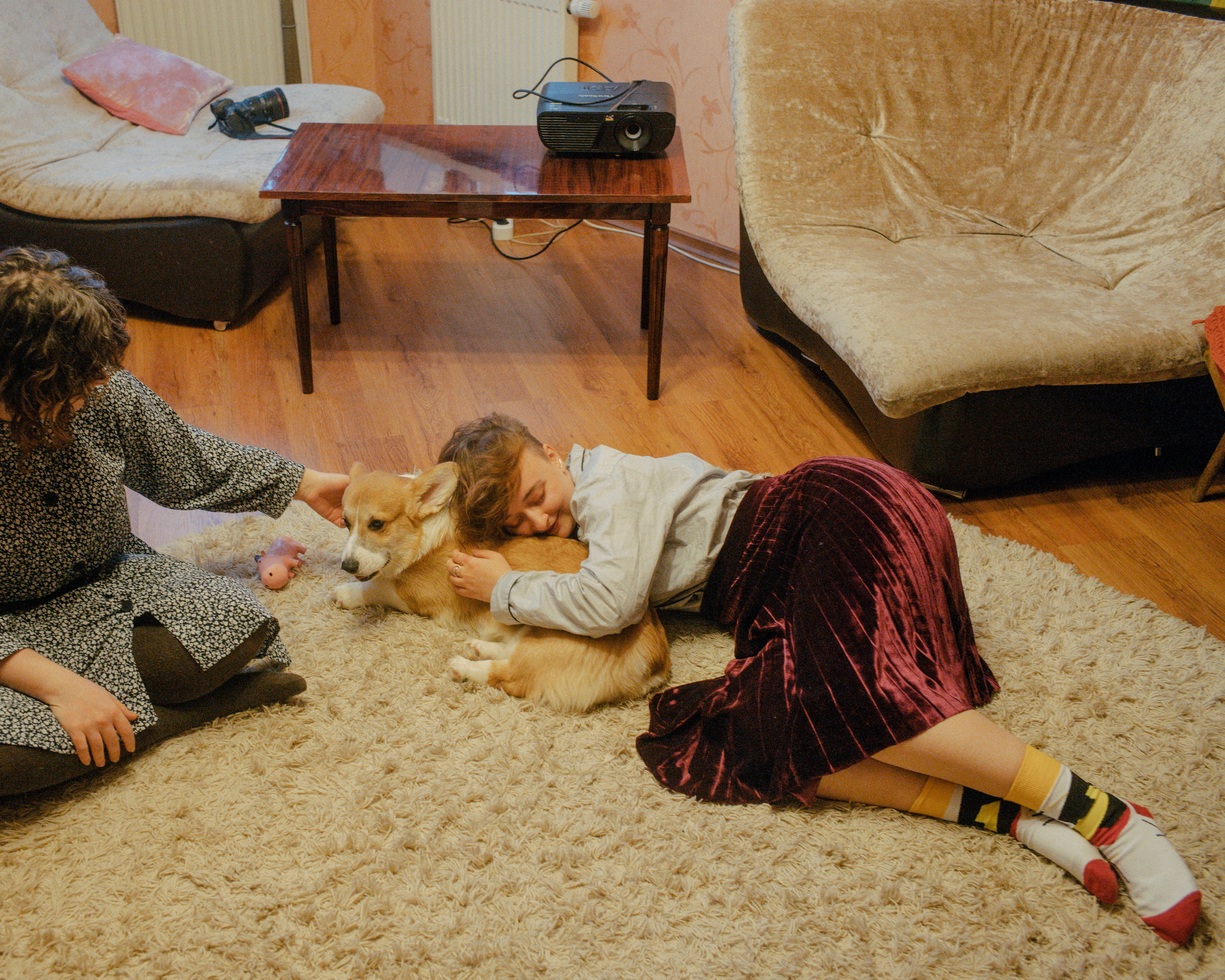 Daria Serenko, right, and Sonia Sno play with a corgi that belongs to a guest staying at Femdacha