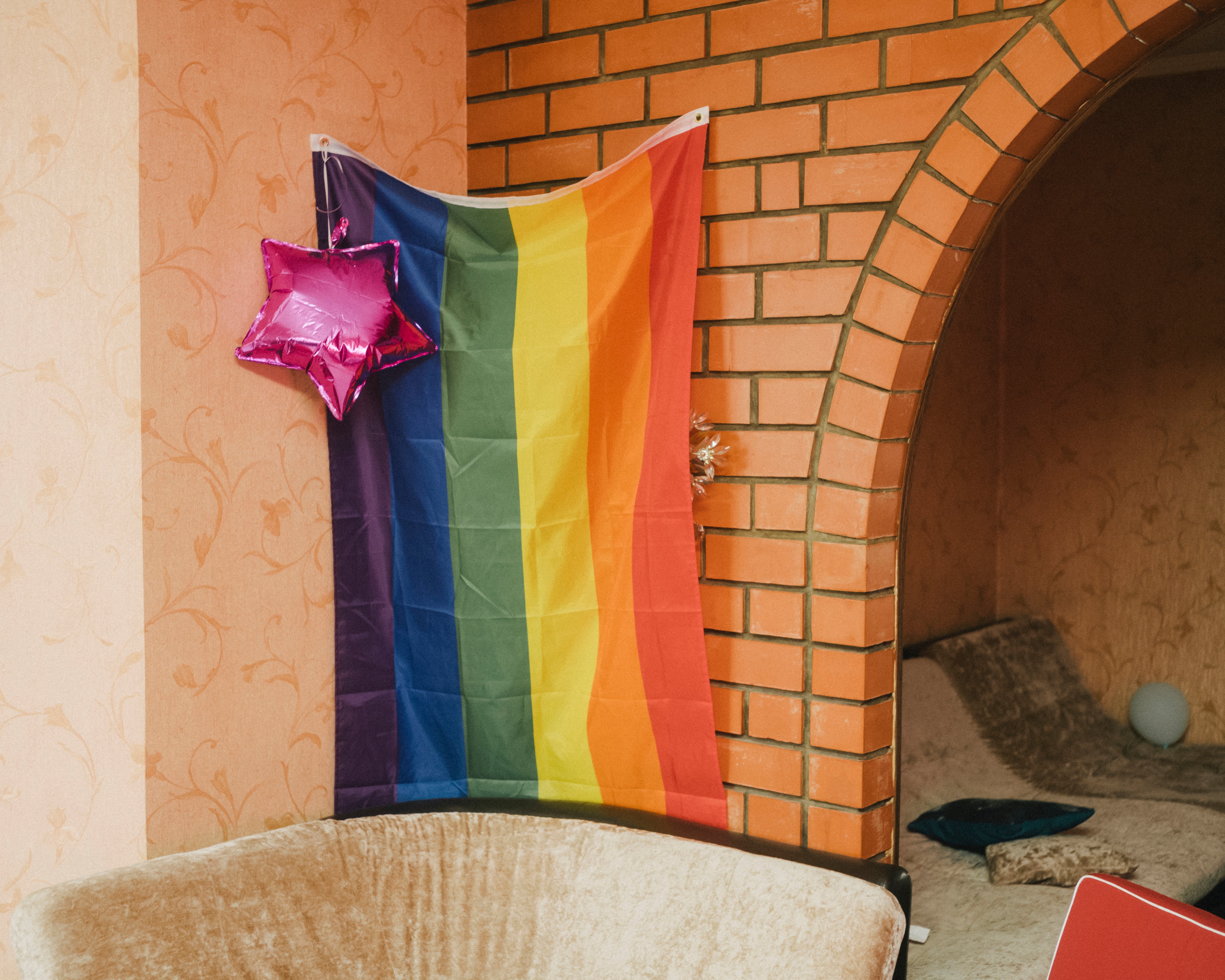 A pink balloon and an LGBTQ rainbow flag hang in the living room