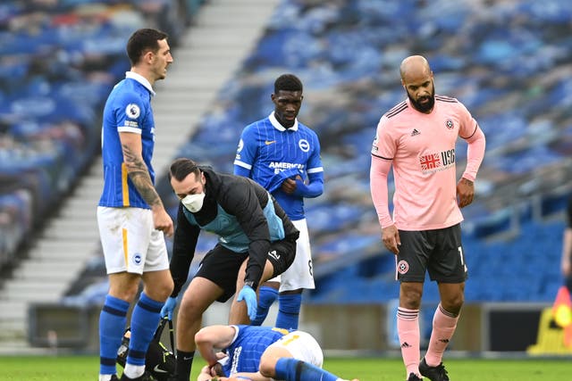 Brighton striker Neal Maupay receives treatment for a head injury