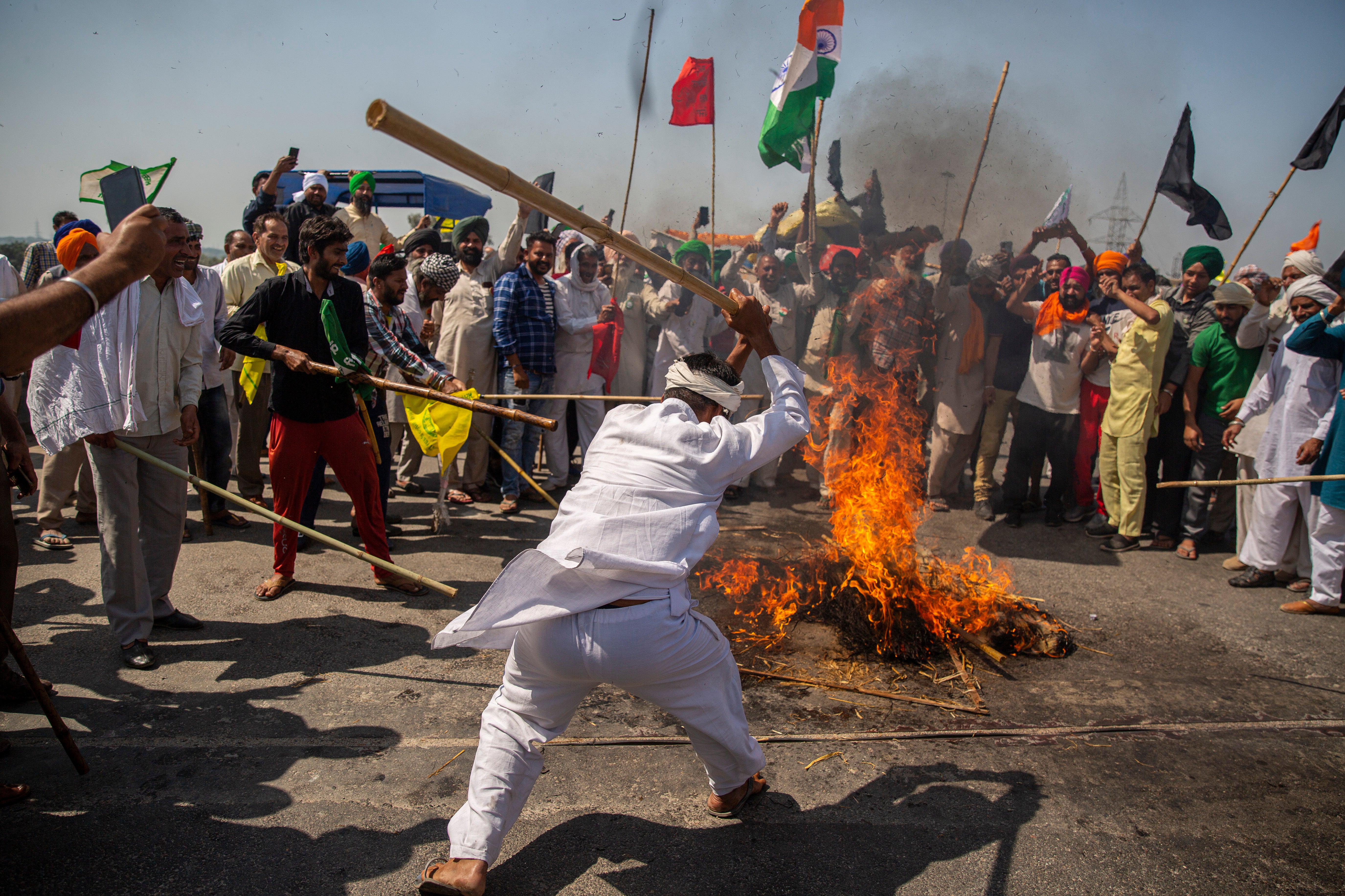 Indian farmers beat a burning mock corpse representing Indian prime minister Narendra Modi on Saturday, marking 100 days of the protests against new farm laws
