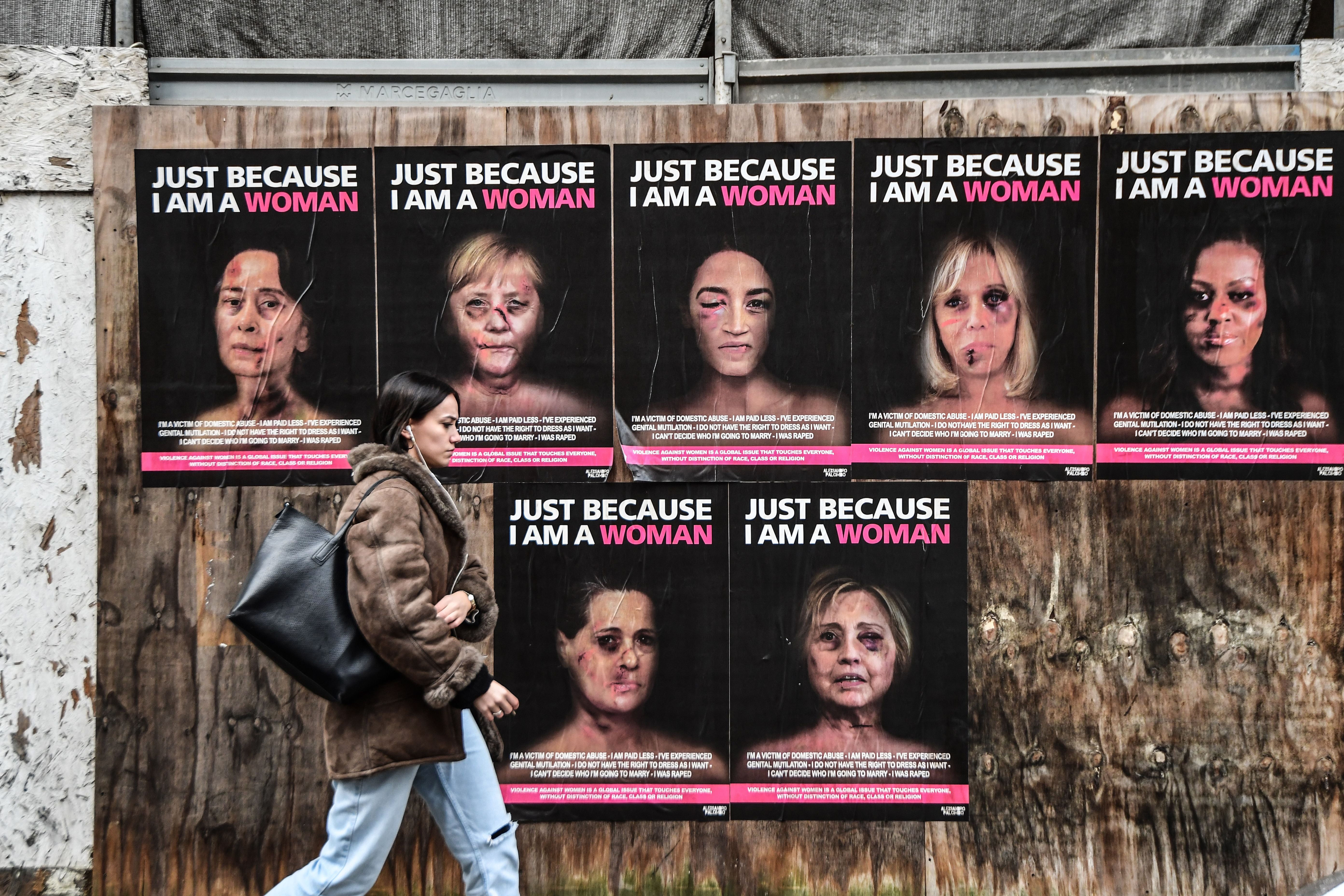 Woman strolls past series by Italian artist aleXsandro Palombo showing high-profile politicians as victims of gender-based violence