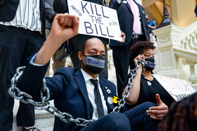 <p>Demonstrators wear chains while holding a sit-in inside of the Capitol building in opposition of House Bill 531 on March 8, 2021 in Atlanta,Georgia. HB531 will restrict early voting hours, remove drop boxes, and require the use of a government ID when voting by mail.</p>