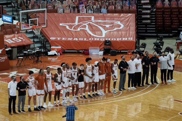 FILE - In this Sunday, Dec. 20, 2020, file photo, Texas players sing "The Eyes Of Texas" after an NCAA college basketball game against Oklahoma State in Austin, Texas. The University of Texas' long-awaited report on the history of the school song “The Eyes of Texas? found it had “no racist intent,? but the school will not require athletes and band members to participate in singing or playing it at games and campus events. The song had erupted in controversy in 2020 after some members of the football team demanded the school stop playing it because of racist elements in the song’s past. (AP Photo/Chuck Burton, File)