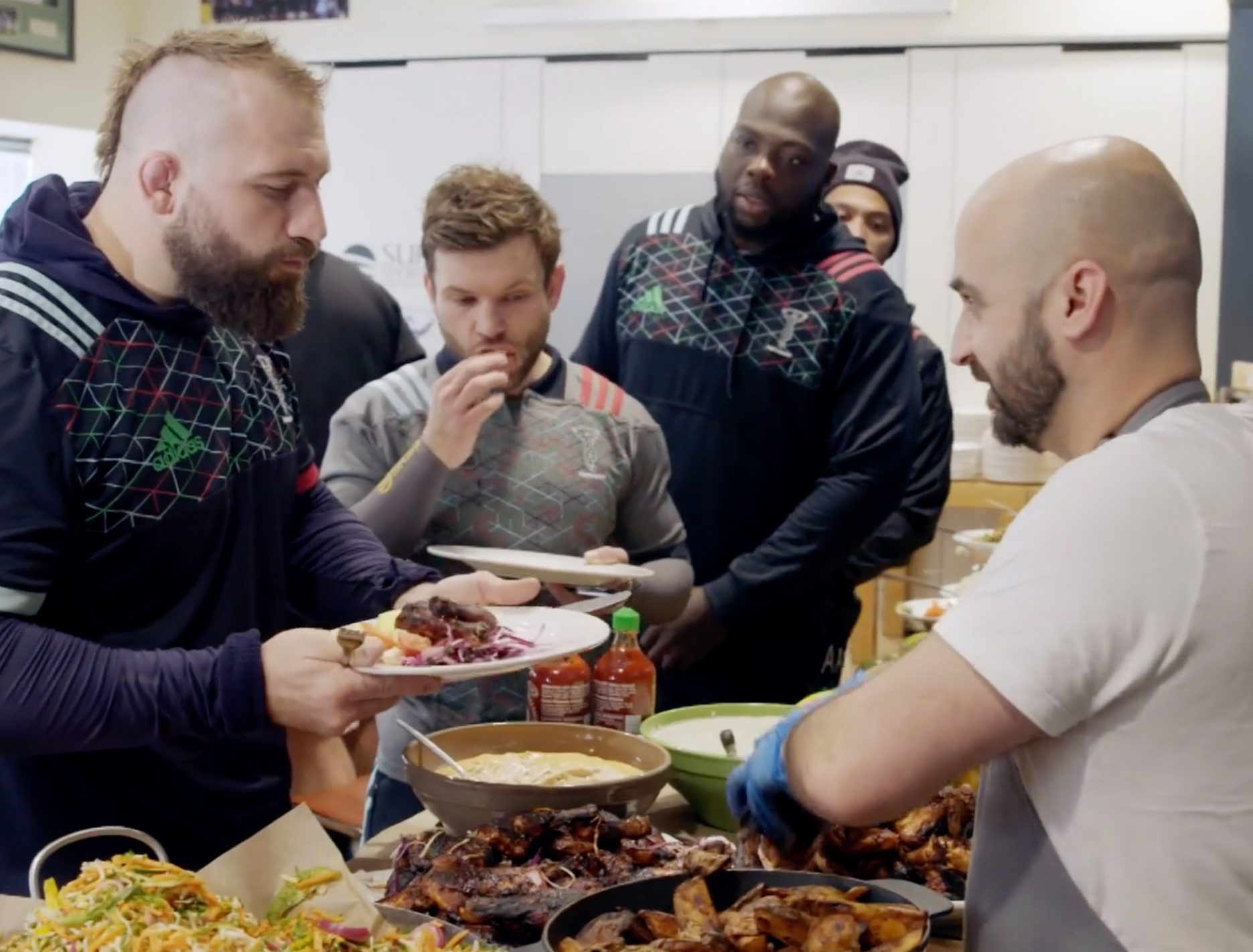 Meziane dishes up his food to Harlequins rugby player Joe Marler