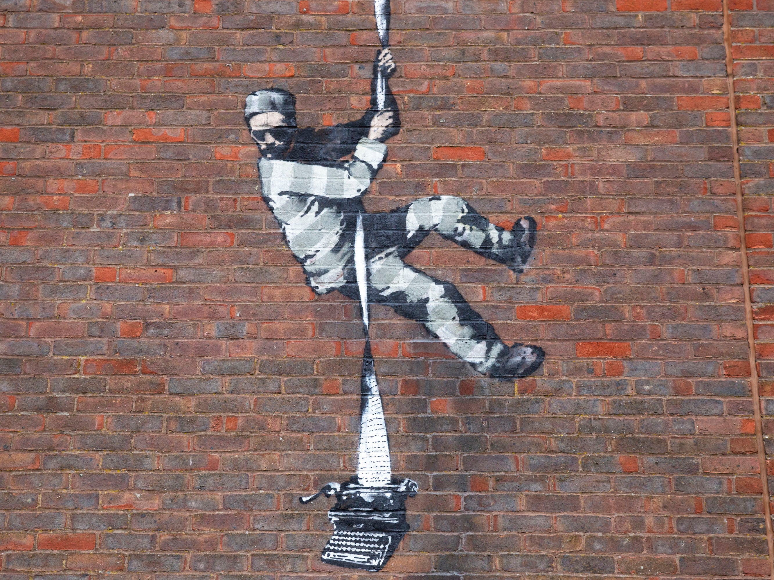 A view of the recent Banksy artwork that has been placed on a side wall of a redundant prison in Reading, Britain