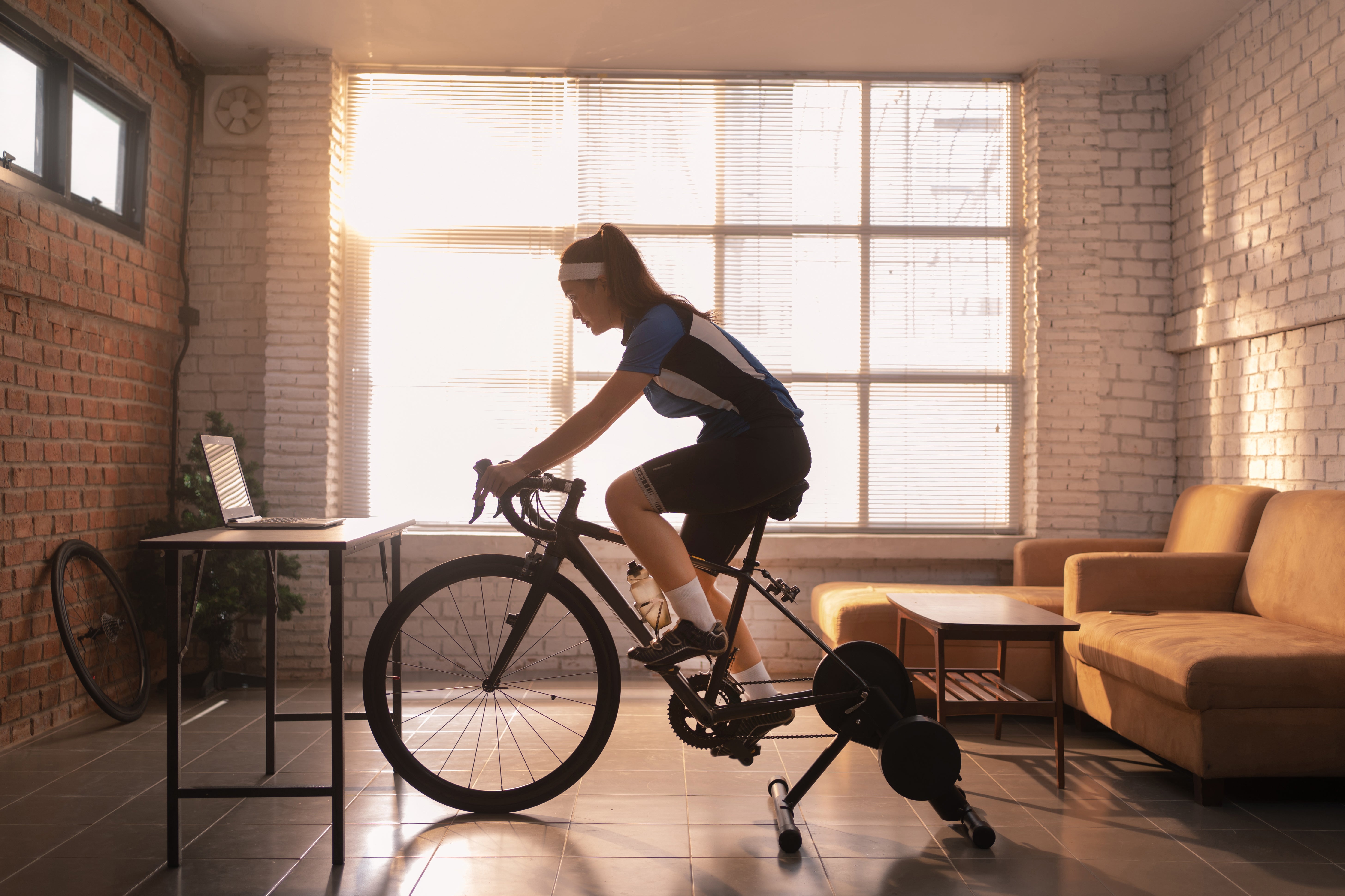 Woman riding an exercise bike in the living room (
