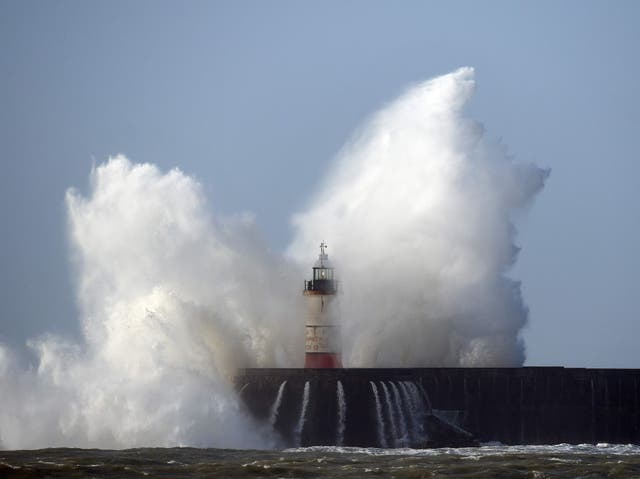 Waves crash over the harbour wall in Newhaven, southern England