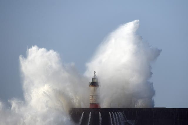Waves crash over the harbour wall in Newhaven, southern England