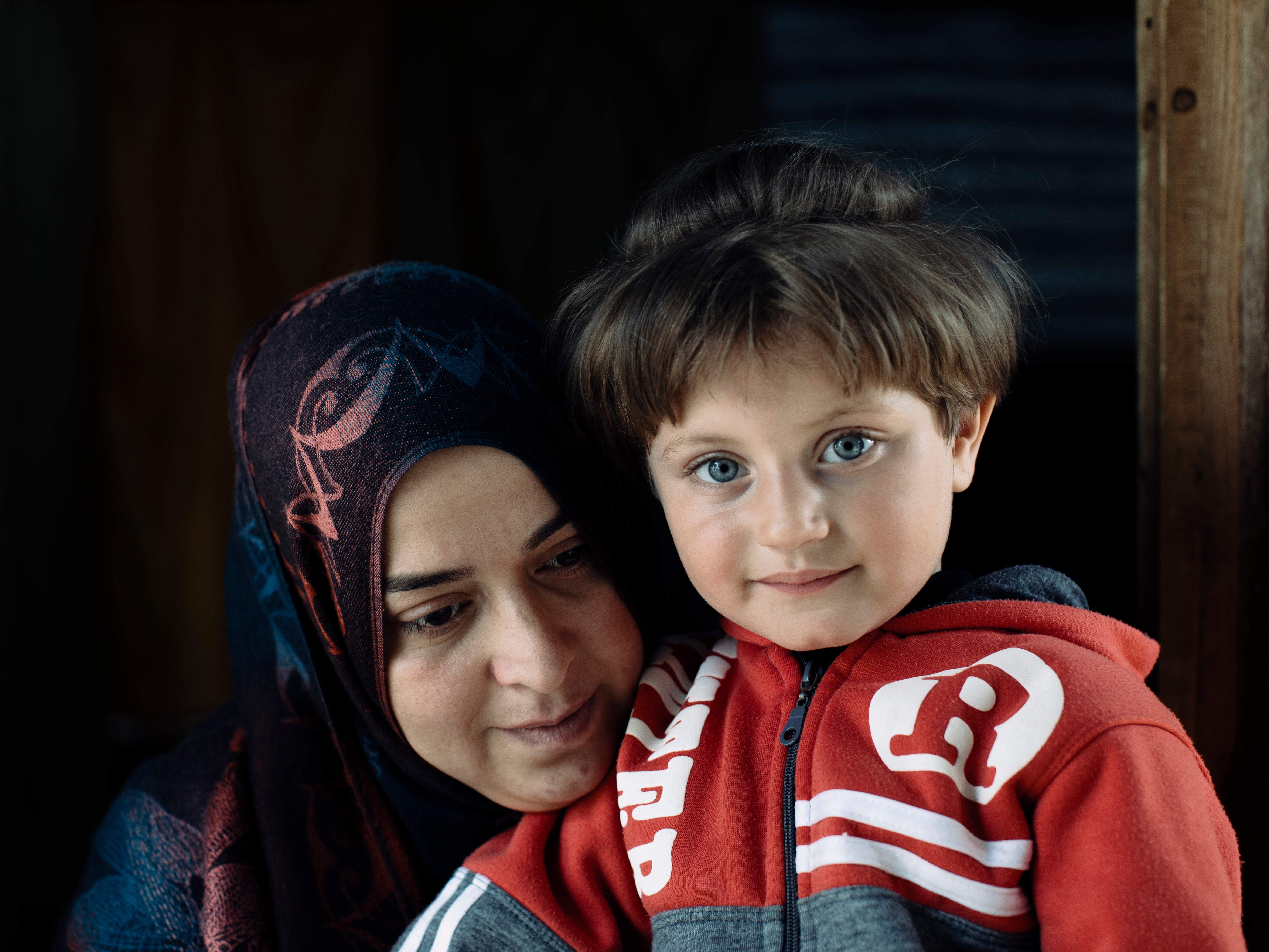 In Enmaa camp, Wardi takes care of a neighbours child. She has 4 children of her own; they left Homs in 2013 after heavy bombardments and a lack of food. They travelled for 4 days to reach the border. Years on they still suffer acute hunger at times surviving on food vouchers through the UN.