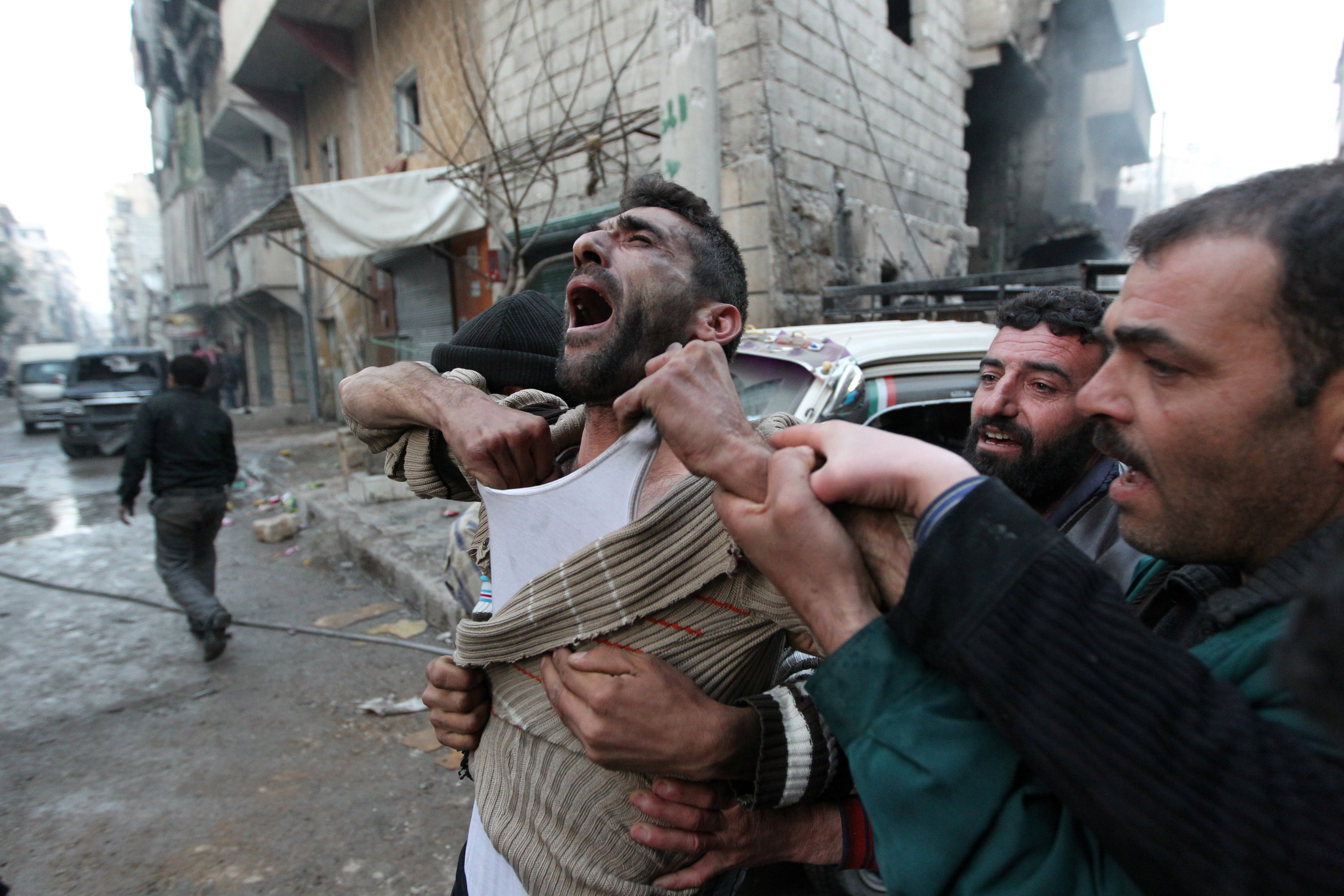 A father reacts after the death of two of his children, whom activists said were killed by shelling by forces loyal to Syria’s president Bashar al-Assad, at al-Ansari area in Aleppo, Syria in January 2013