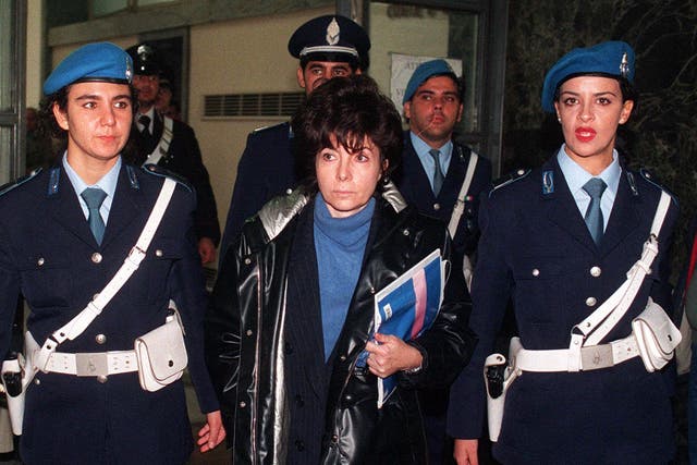 Patrizia Reggiani is escorted by police officers into Milan’s court on 3 November 1998